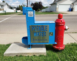 Blue water fountain attached to a red fire hydrant