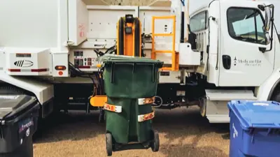 garbage truck collecting a yard waste bin