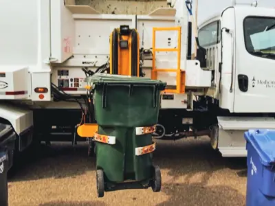 garbage truck collecting a yard waste bin