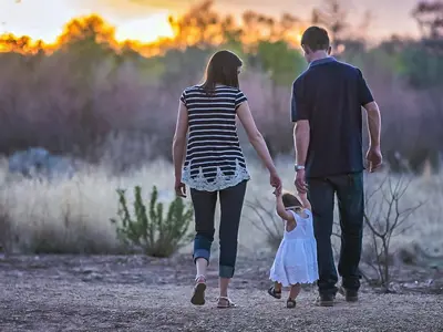 alt="parents walking with a child"