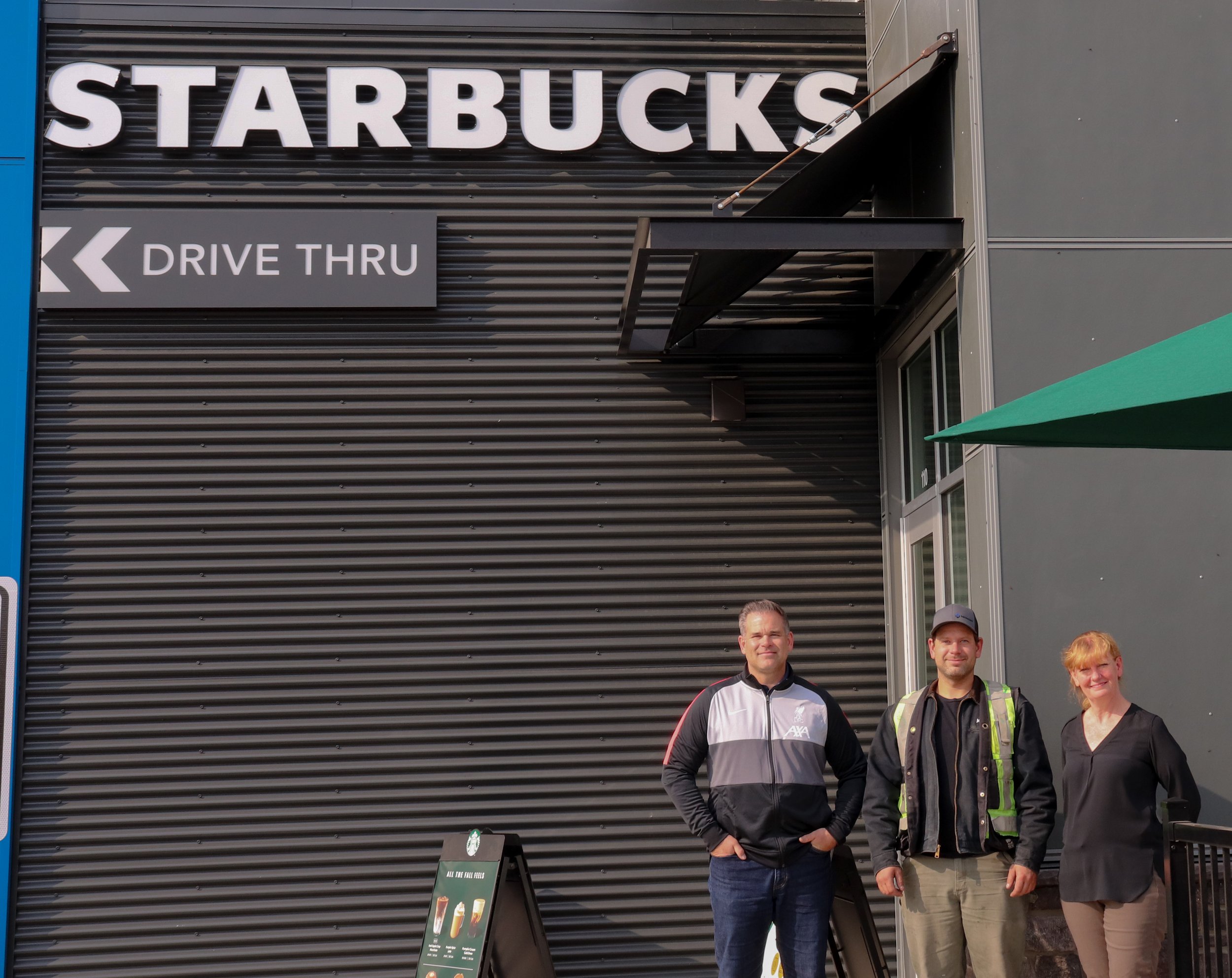 Staff of Mid-West Design stand proudly in front of newest development.