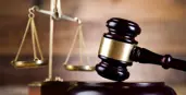  alt="Photo of gavel on a chestnut coloured table"