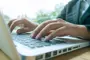 alt="closeup of a person using a laptop"