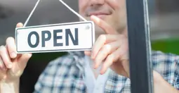 man with open sign on door